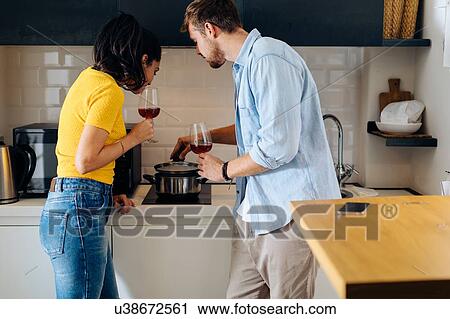 Young couple cooking in kitchen View Large Photo Image Stock Image - Young couple cooking in kitchen. Fotosearch