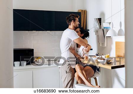 Young couple hugging in kitchen View Large Photo Image Stock Image - Young couple hugging in kitchen. Fotosearch