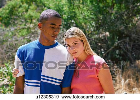 Stock Photo - Young couple in park, portrait, Los Angeles, California, USA. Fotosearch