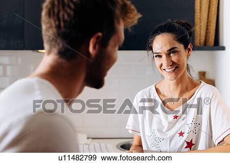 Young couple talking in kitchen View Large Photo Image Stock Photo - Young couple talking in kitchen. Fotosearch
