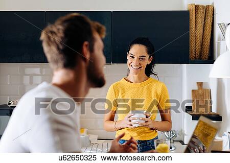 Stock Photography - Young couple talking in kitchen. Fotosearch