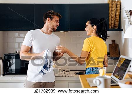 Young couple washing up in kitchen View Large Photo Image Stock Photo - Young couple washing up in kitchen. Fotosearch