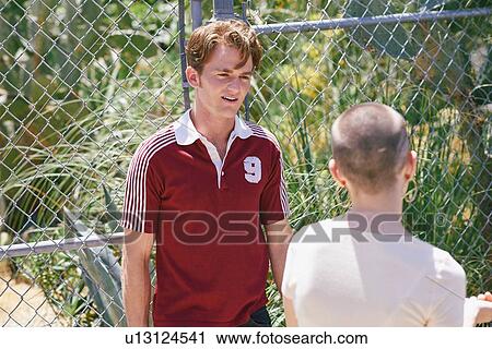 Stock Image - Young man and female friend on suburban sidewalk, Los Angeles, California, USA. Fotosearch