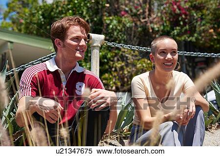 Young man and female friend sitting in park, Los Angeles, California, USA View Large Photo Image Stock Photography - Young man and female friend sitting in park, Los Angeles, California, USA. Fotosearch