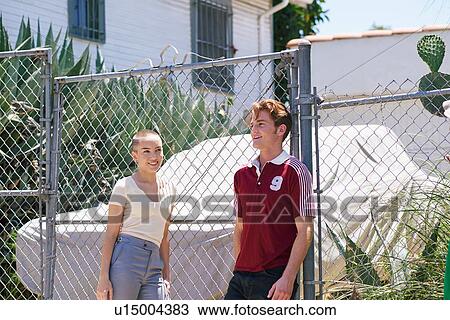 Stock Image - Young man and teenage girl on suburban sidewalk, Los Angeles, California, USA. Fotosearch
