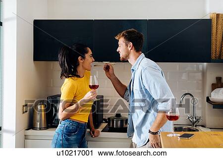 Young man feeding woman in kitchen View Large Photo Image Stock Image - Young man feeding woman in kitchen. Fotosearch