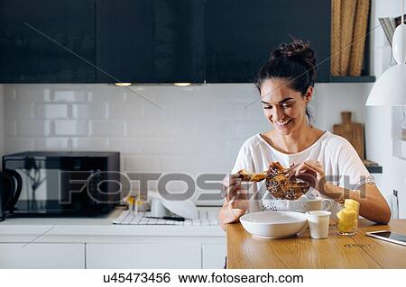 Young woman breaking croissant in kitchen View Large Photo Image Stock Photograph - Young woman breaking croissant in kitchen. Fotosearch