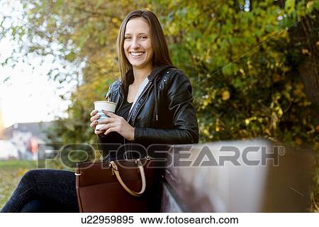 Stock Photography - Young woman on coffee break in park. Fotosearch