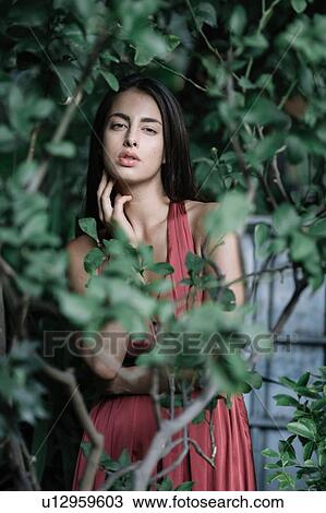Stock Image - Young woman touching neck. Fotosearch