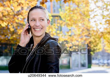 Young woman using smartphone in park View Large Photo Image Picture - Young woman using smartphone in park. Fotosearch