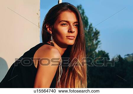 Young woman with long brown hair gazing outside building, head and shoulder portrait View Large Photo Image Stock Image - Young woman with long brown hair gazing outside building, head and shoulder portrait. Fotosearch