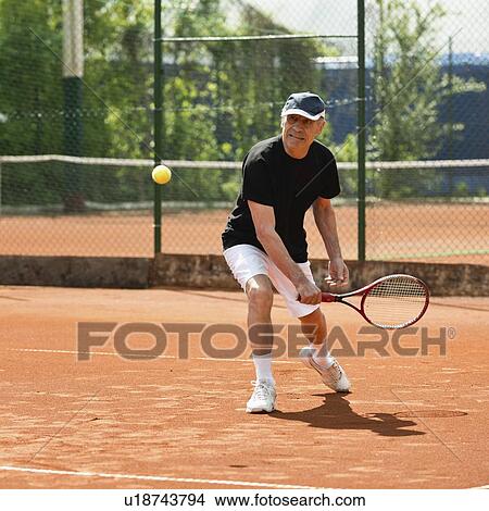 Picture - Active senior man playing tennis. Fotosearch