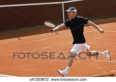 Stock Image - Active senior man playing tennis. Fotosearch
