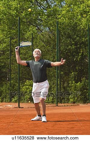 Stock Photo - Active senior man playing tennis. Fotosearch