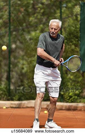 Stock Photo - Active senior man playing tennis. Fotosearch