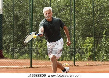 Stock Photo - Active senior man playing tennis. Fotosearch