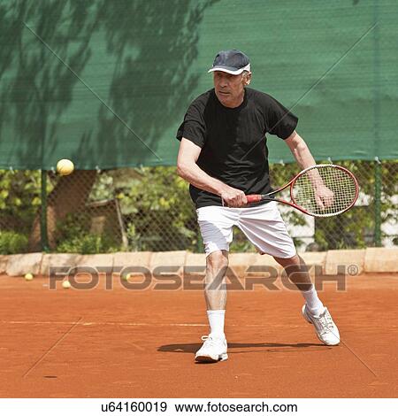 Stock Photo - Active senior man playing tennis. Fotosearch