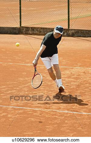 Stock Photograph - Active senior man playing tennis. Fotosearch