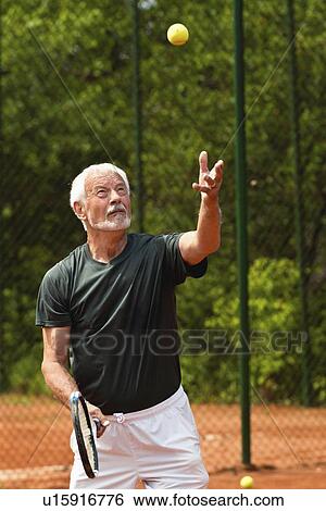 Stock Photograph - Active senior man playing tennis. Fotosearch
