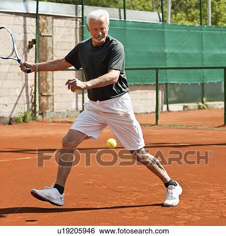 Stock Photograph - Active senior man playing tennis. Fotosearch