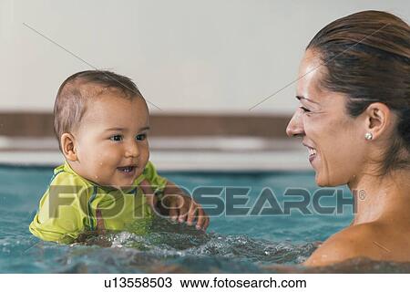 Stock Image - Baby boy and mother in swimming pool. Fotosearch