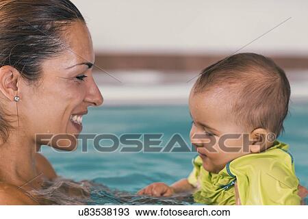 Stock Image - Baby boy and mother in swimming pool. Fotosearch
