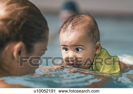Stock Image - Baby swimming lesson. Fotosearch