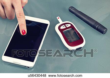 Stock Photo - Blood sugar test at home. Fotosearch