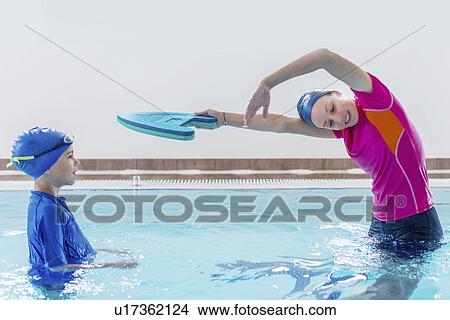 Picture - Boy having a swimming lesson with instructor. Fotosearch
