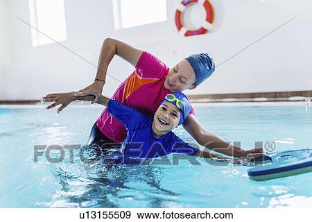 Stock Photo - Boy having a swimming lesson with instructor. Fotosearch