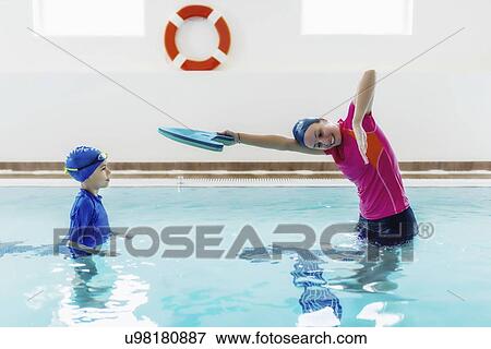 Stock Photo - Boy having a swimming lesson with instructor. Fotosearch