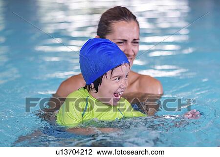 Stock Image - Boy in swimming pool with mother. Fotosearch