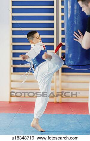 Boy kicking punching bag View Large Photo Image Stock Photo - Boy kicking punching bag. Fotosearch