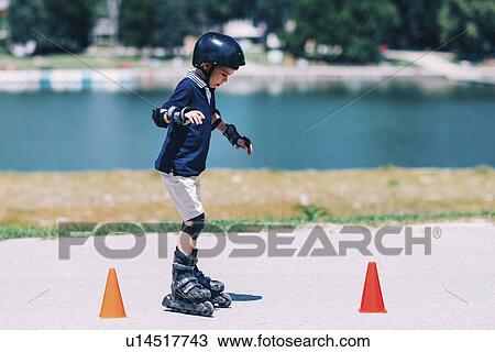 Stock Image - Boy learning to roller skate. Fotosearch