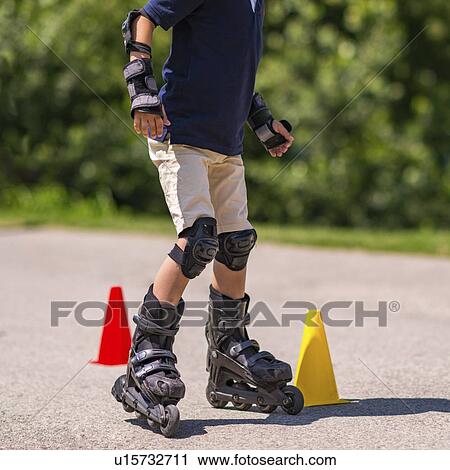 Stock Image - Boy learning to roller skate. Fotosearch