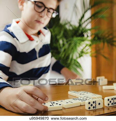 Stock Image - Boy playing dominoes. Fotosearch