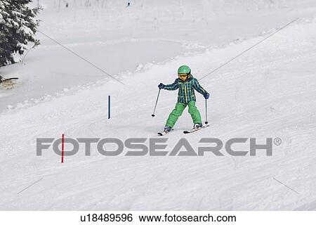 Stock Photograph - Boy skiing down hill. Fotosearch