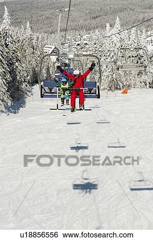 Boy with ski instructor on ski lift View Large Photo Image Stock Photograph - Boy with ski instructor on ski lift. Fotosearch