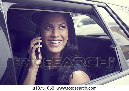 Stock Image - Business woman sitting in car. Fotosearch