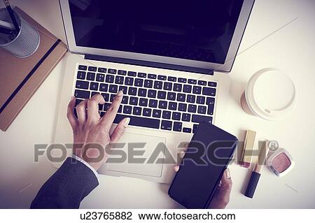 Stock Image - Business woman using laptop. Fotosearch