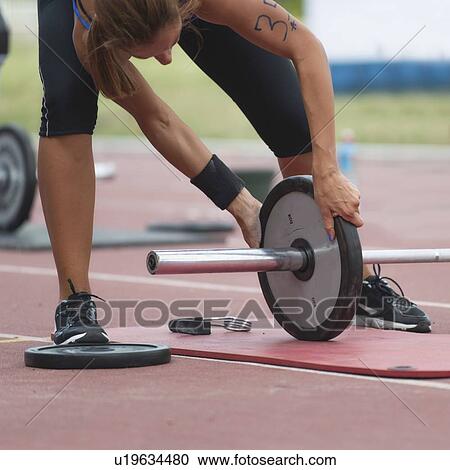 Changing weights on barbell View Large Photo Image Stock Image - Changing weights on barbell. Fotosearch