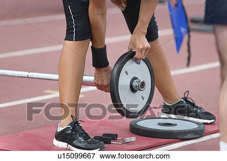 Changing weights on barbell View Large Photo Image Stock Photo - Changing weights on barbell. Fotosearch