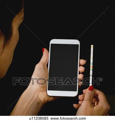 Stock Image - Checking test strips from urine sample. Fotosearch