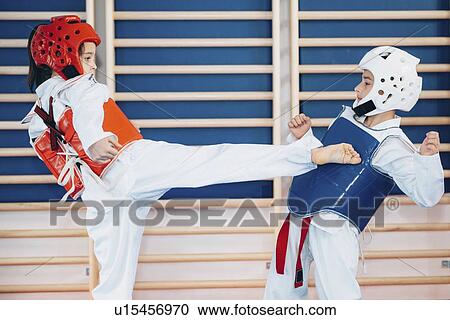 Stock Image - Children sparring in taekwondo class. Fotosearch