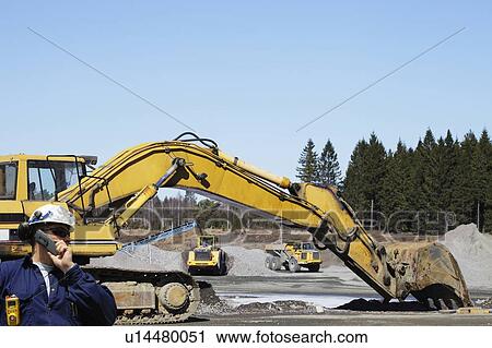 Stock Image - Construction worker and bulldozer. Fotosearch