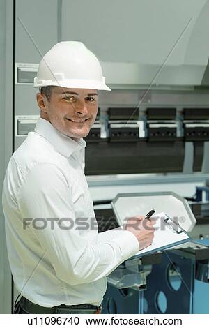 Stock Image - Engineer working in factory. Fotosearch