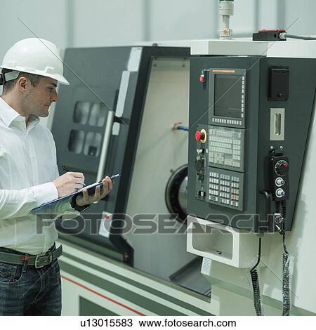 Stock Image - Engineer working in factory. Fotosearch