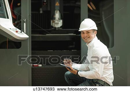 Stock Image - Engineer working in factory. Fotosearch