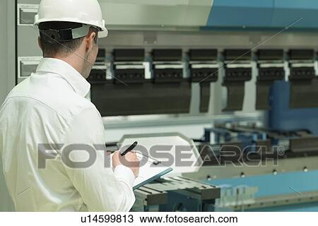 Stock Image - Engineer working in factory. Fotosearch