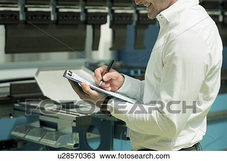 Stock Image - Engineer working in factory. Fotosearch